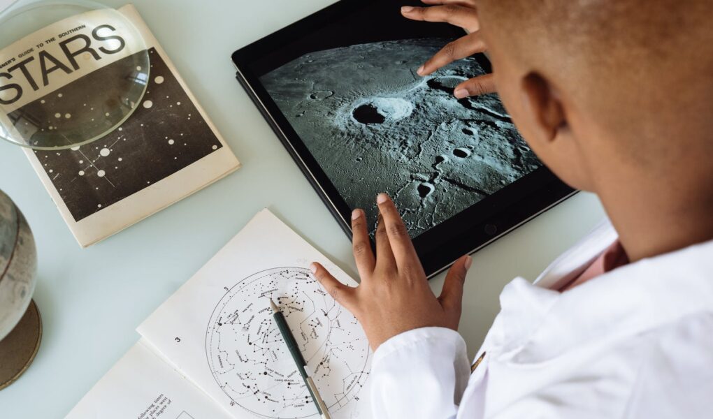 crop african american student studying craters of moon on tablet at observatory