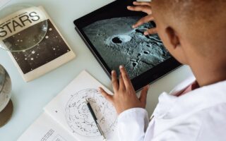 crop african american student studying craters of moon on tablet at observatory